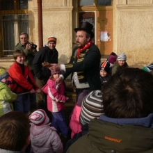 Představitel divadelní společnosti ukazuje utrženou ruku dítěte, kterou medvěd vyhodil zpoza závěsu. 